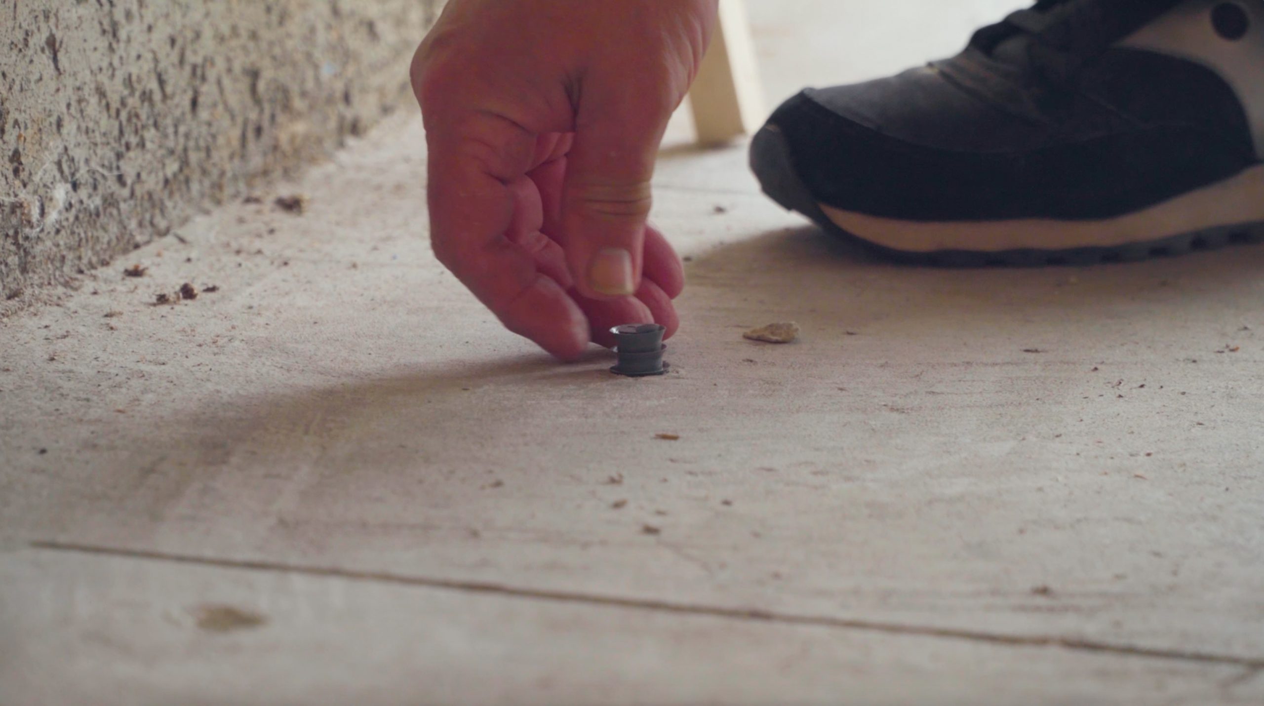 pest control technician capping and sealing holes in concrete