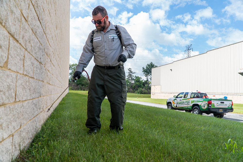Technicians_treating+Meta_website-3 Green Pest management technicians spraying warehouse foundation