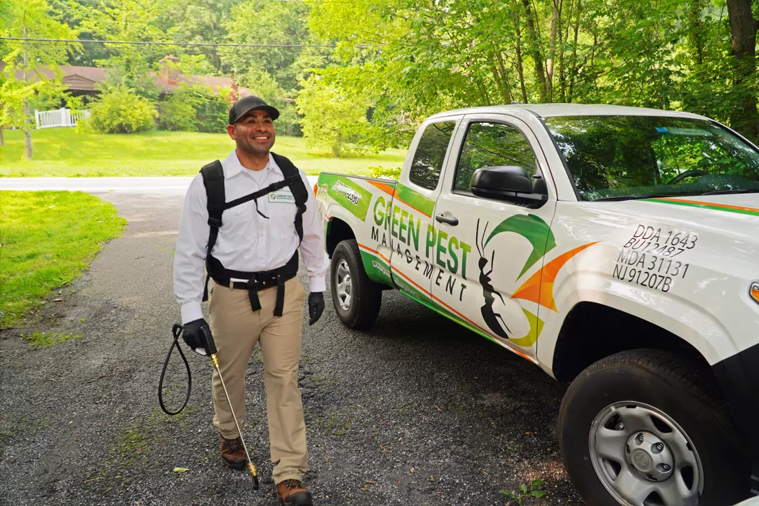 Technician_Wilmington_Delaware Green Pest Management technician walking by truck treating for residential pest control