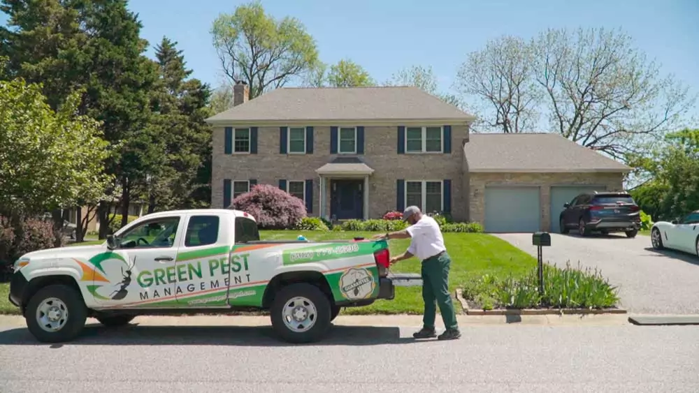 local pest control truck and technician next to Pennsylvania home